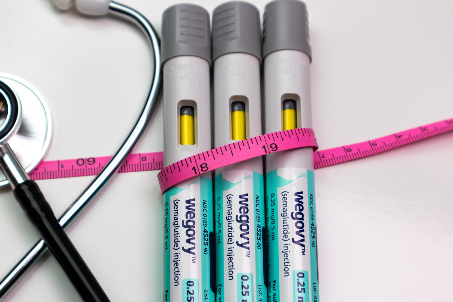 Wegovy weight-loss injection pen placed next to a measuring tape – symbolising medical approach to reducing body measurements and managing obesity