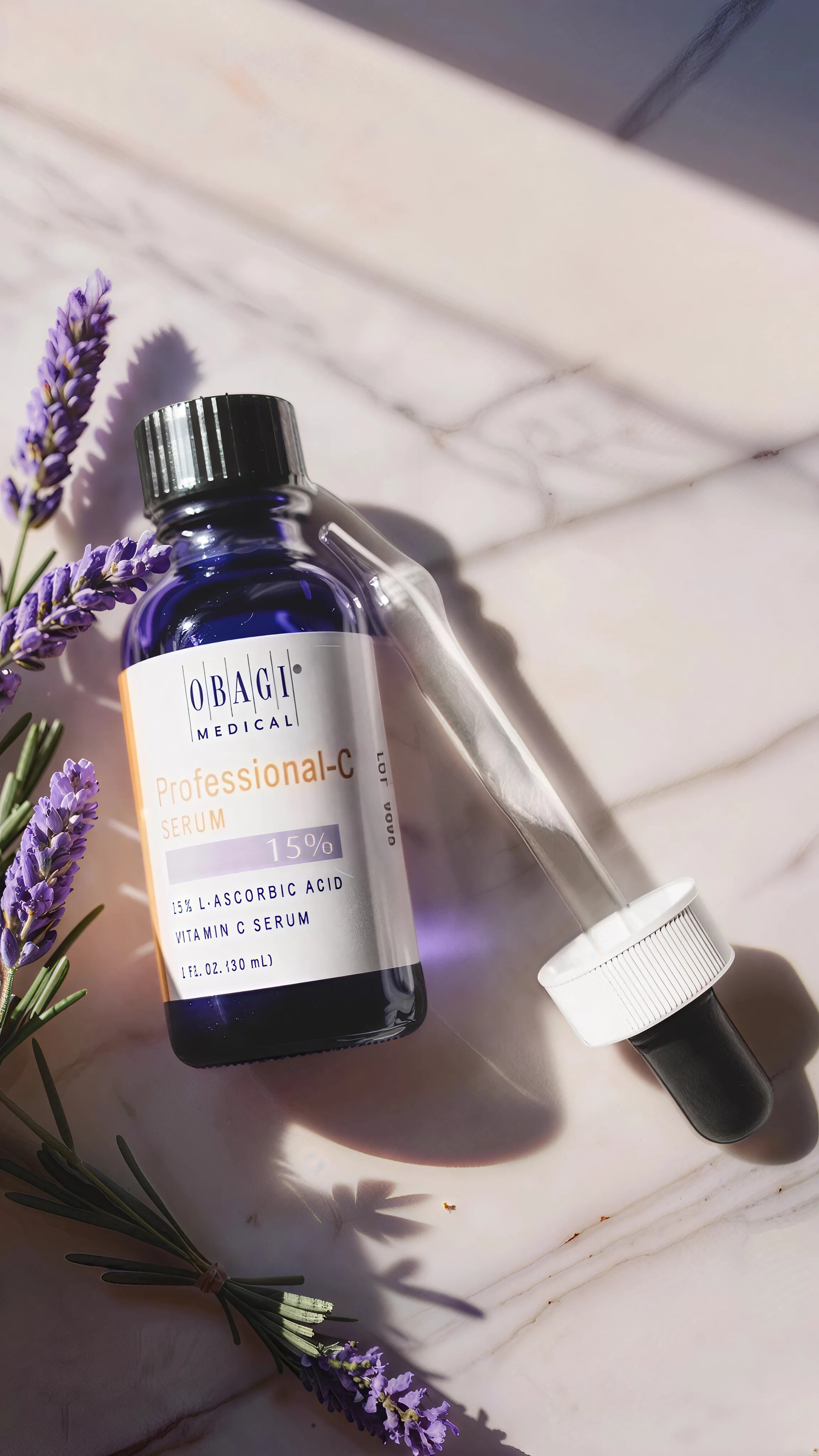 Obagi Medical serum bottle with dropper on a light wooden surface with lavender flowers.