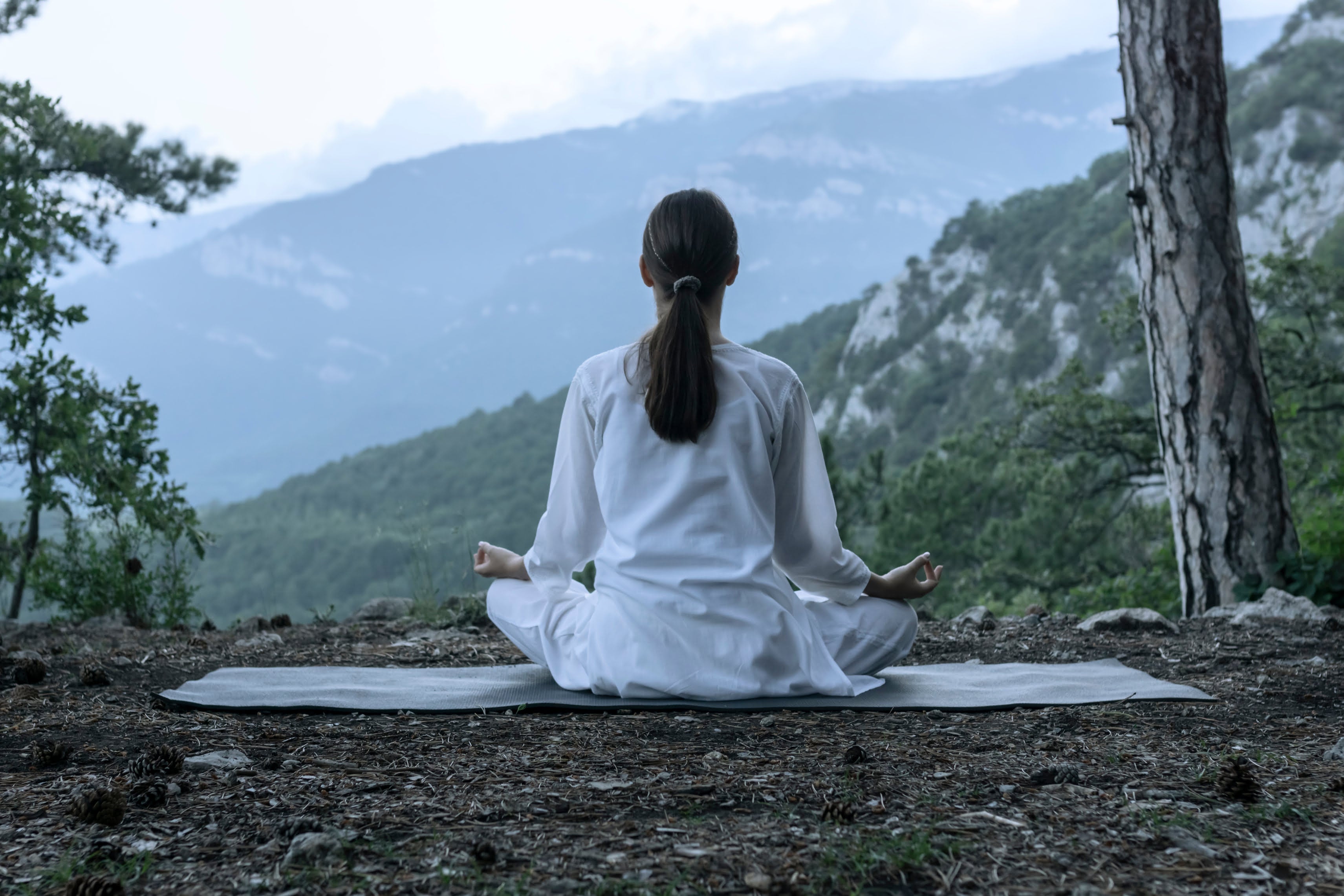 Calm woman meditating with serene background, representing physical recovery, hydration, and inflammation relief associated with IV drip treatments.