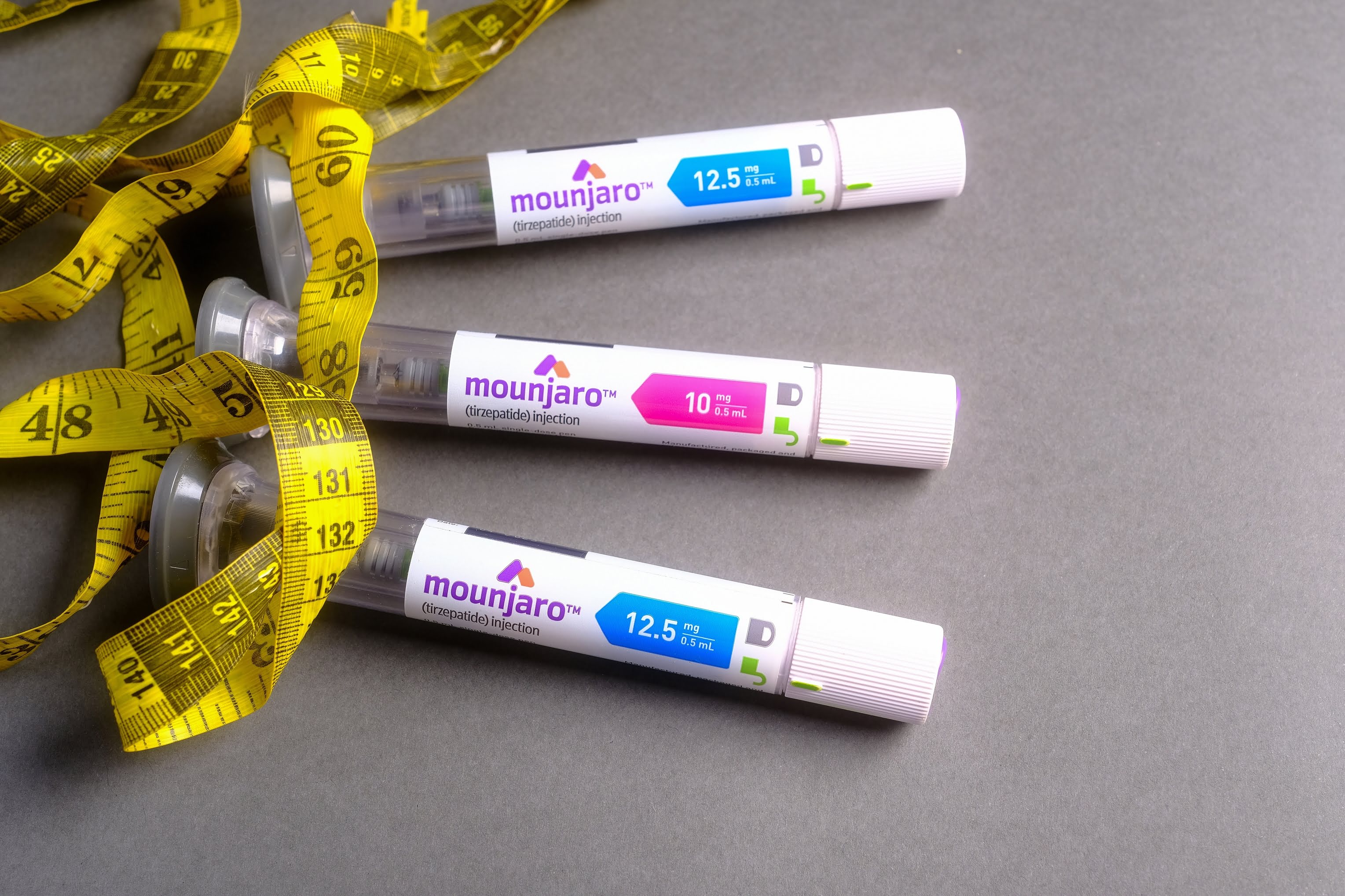 Injection of Mounjaro with measuring tape – symbolising effective weight loss and visible reduction in body measurements