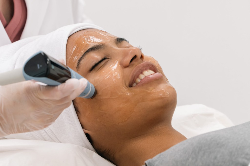 woman receiving a rf facial ultrasound treatment with a device on her face